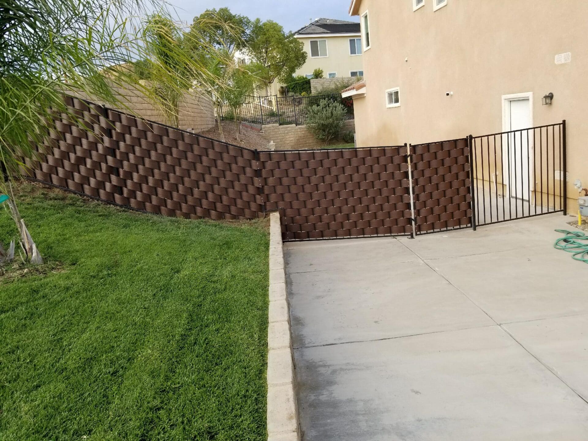 A fence that is in the grass near a house.