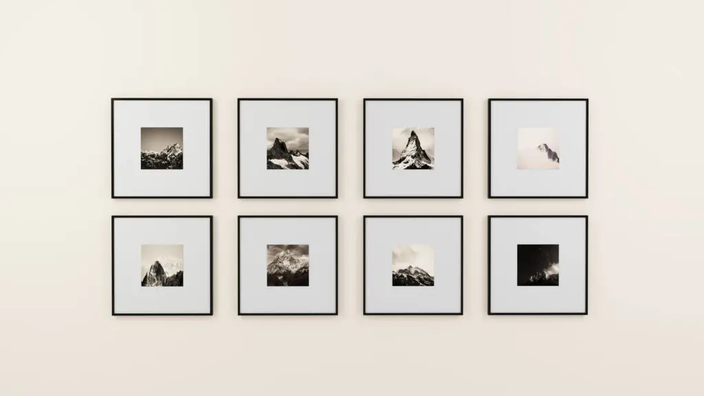 A wall with eight black and white photographs of mountains.